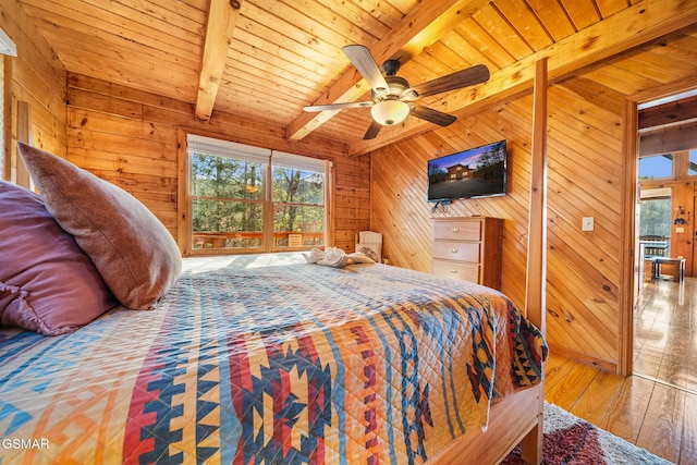 bedroom with beam ceiling, wood walls, ceiling fan, and wooden ceiling