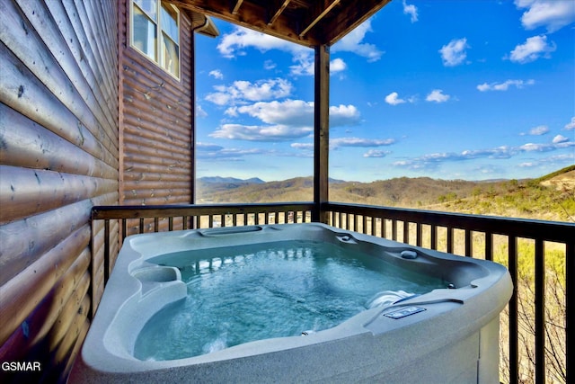 wooden terrace with a mountain view and a hot tub