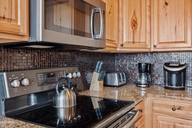 kitchen featuring stainless steel appliances, backsplash, and light brown cabinetry