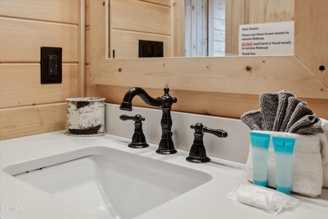 interior details featuring a sink and wooden walls