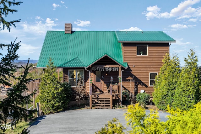 view of front of house with metal roof and a chimney