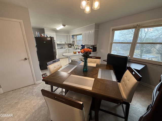 dining space featuring baseboards and an inviting chandelier