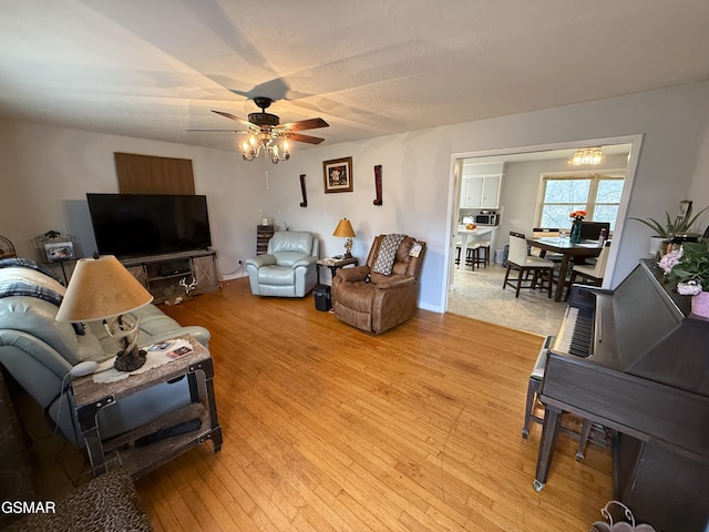 living area with light wood-type flooring and a ceiling fan