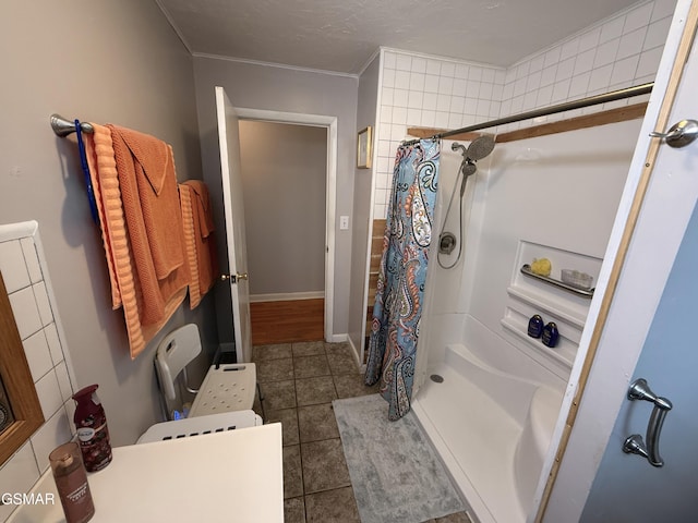 bathroom with a shower stall, baseboards, and tile patterned floors