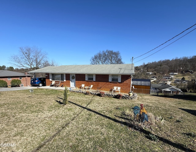 ranch-style home featuring a front yard, brick siding, and driveway