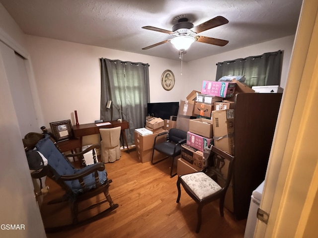 sitting room with a ceiling fan and light wood-style floors