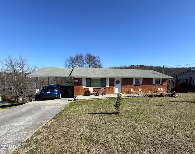 single story home with a carport, brick siding, driveway, and a front lawn