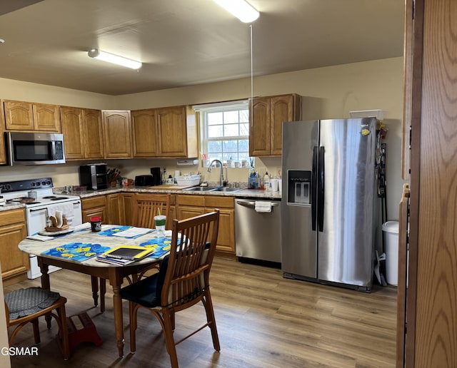 kitchen featuring light wood-type flooring, stainless steel appliances, and sink