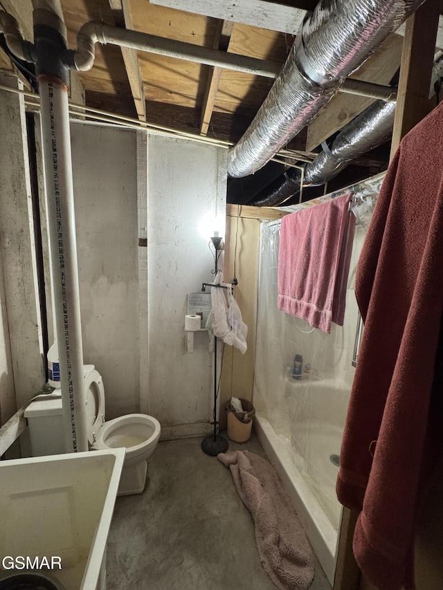 bathroom featuring toilet, concrete flooring, and walk in shower