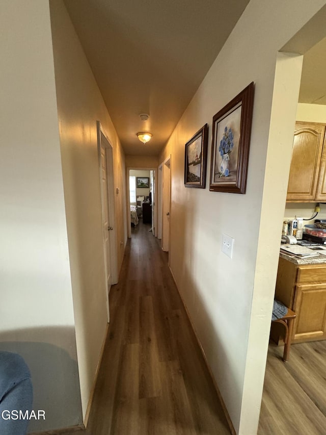 corridor with hardwood / wood-style flooring