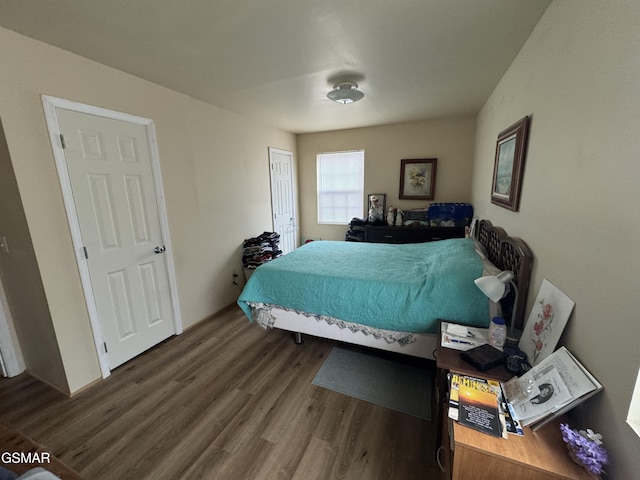 bedroom with dark hardwood / wood-style flooring