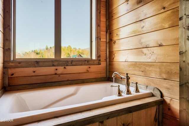 bathroom with a tub to relax in and wood walls