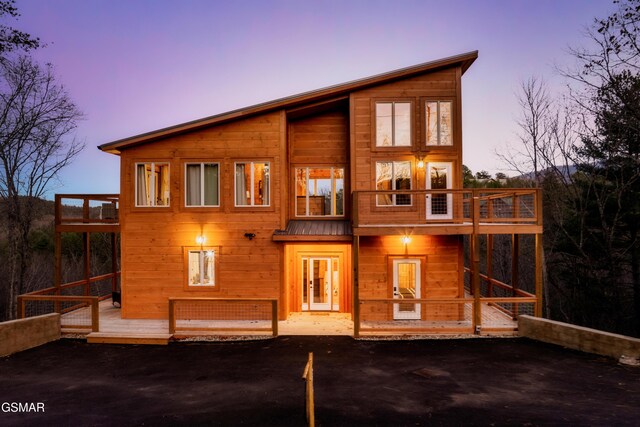 exterior space featuring a balcony, a deck, and french doors