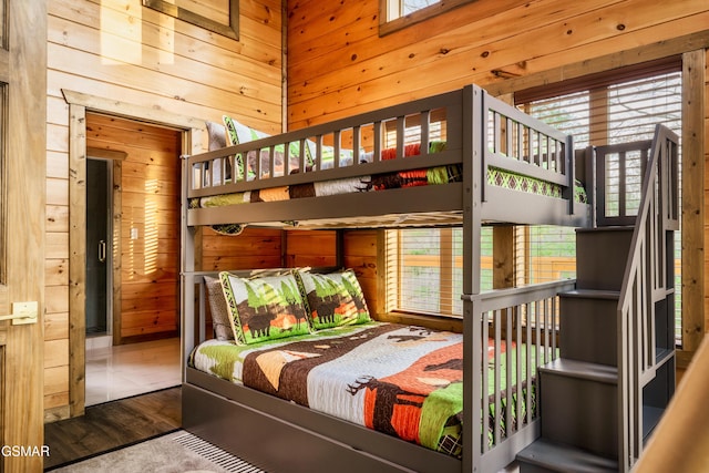 bedroom featuring hardwood / wood-style flooring and wooden walls