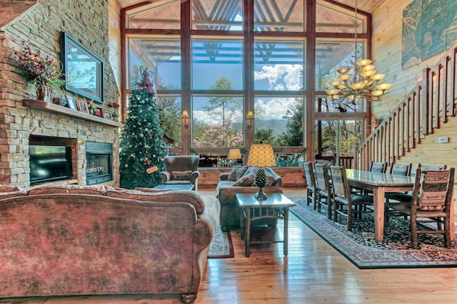 living room with a wealth of natural light, a fireplace, and high vaulted ceiling