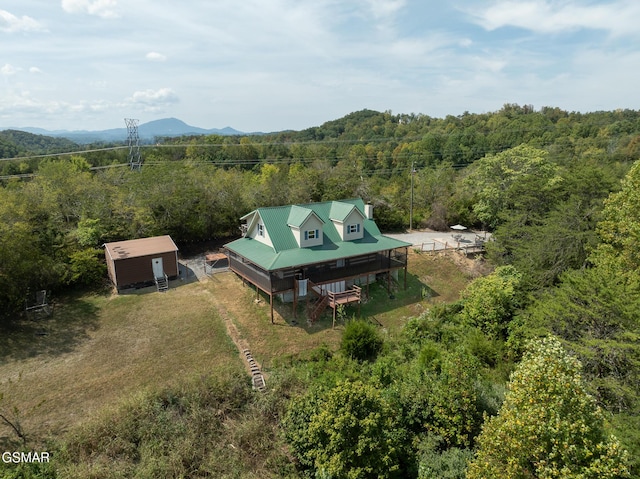birds eye view of property featuring a wooded view and a mountain view