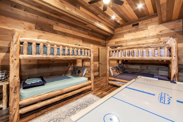 bedroom with ceiling fan, wood walls, and wooden ceiling