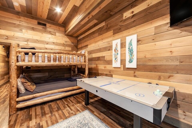 bedroom with hardwood / wood-style floors, wooden ceiling, and wooden walls