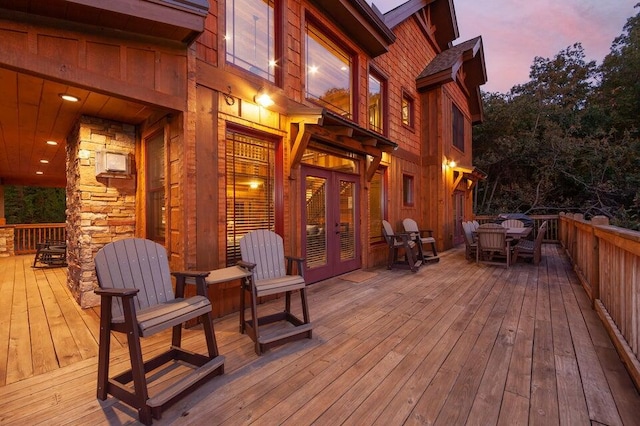 deck at dusk featuring french doors