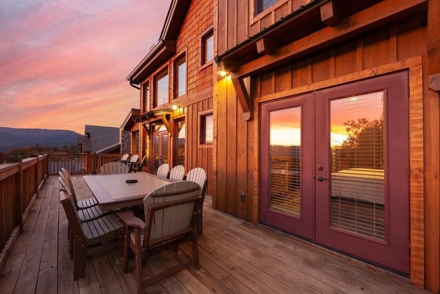 deck at dusk with a mountain view and french doors