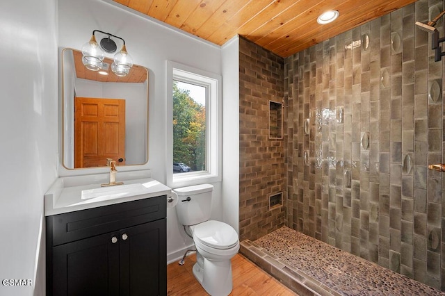 bathroom with hardwood / wood-style floors, vanity, toilet, a tile shower, and wood ceiling