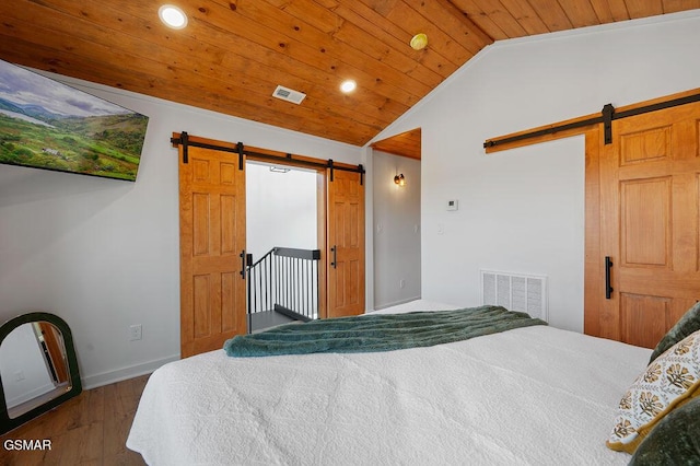 bedroom featuring a barn door, dark hardwood / wood-style flooring, wood ceiling, and lofted ceiling