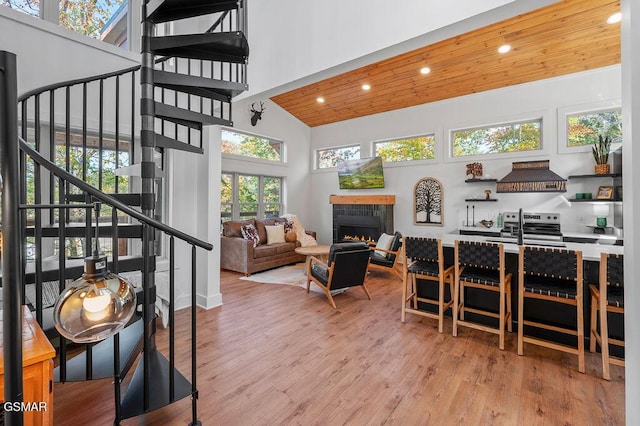 interior space with a tiled fireplace, wood ceiling, and lofted ceiling