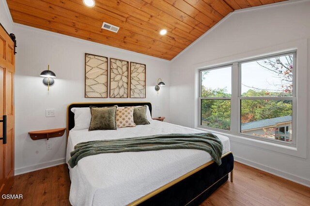 bedroom with a barn door, wood-type flooring, wood ceiling, and multiple windows