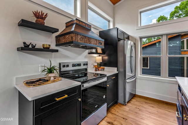 2385 Forge Hideaway Loop Unit 2, Pigeon Forge, TN 37863 - kitchen with appliances with stainless steel finishes, dark cabinets, custom exhaust hood, light wood-type flooring, and light countertops