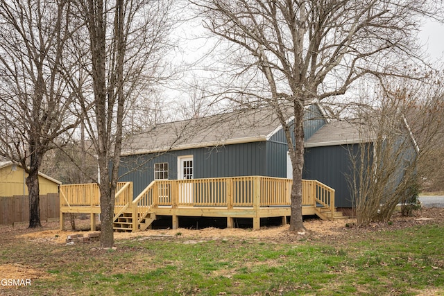 back of property with roof with shingles and a wooden deck