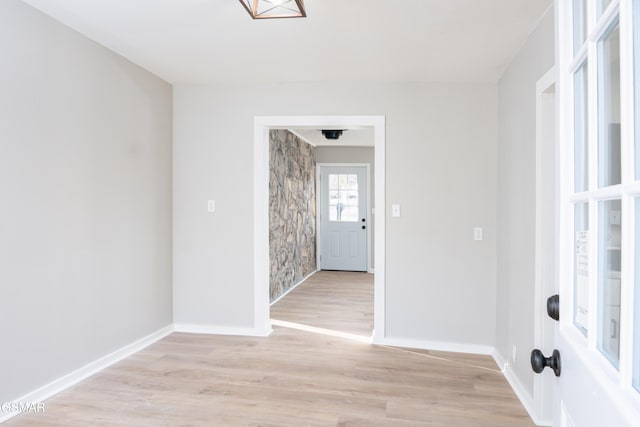 unfurnished room featuring light wood finished floors and baseboards