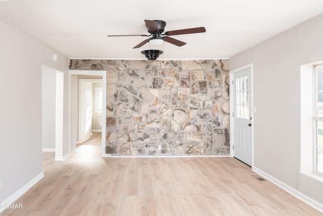 empty room featuring baseboards, visible vents, ceiling fan, and wood finished floors