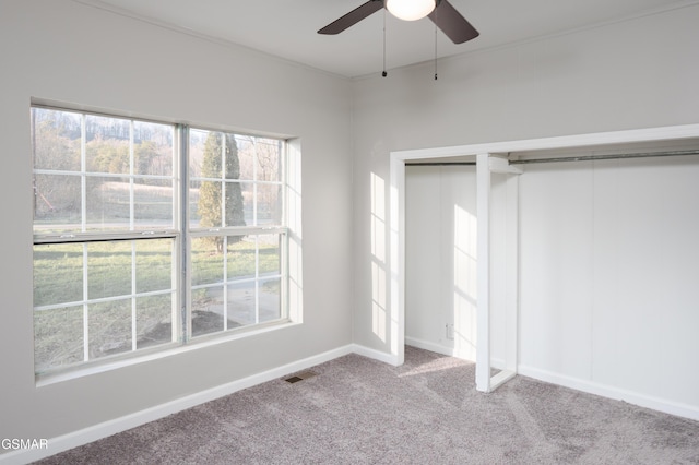 unfurnished bedroom featuring baseboards, visible vents, carpet flooring, and multiple windows