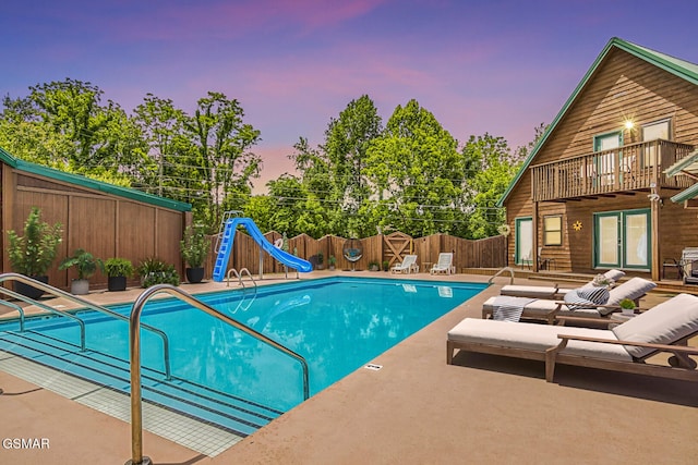 3501 Ginseng Way, Sevierville, TN 37862 - pool at dusk with a water slide, a fenced backyard, a patio, and french doors