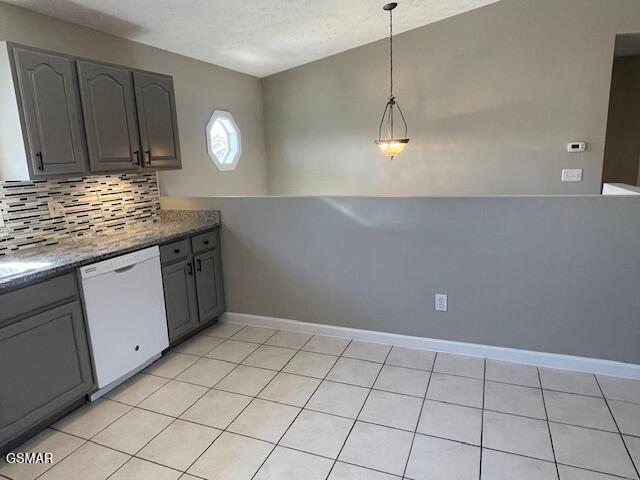 kitchen with baseboards, hanging light fixtures, white dishwasher, gray cabinets, and backsplash