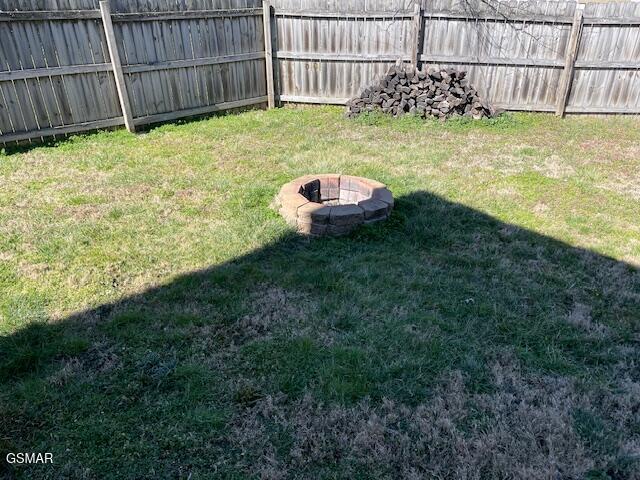 view of yard with fence and a fire pit