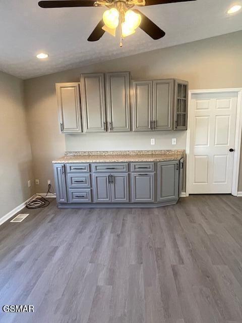 bar featuring lofted ceiling, baseboards, and wood finished floors