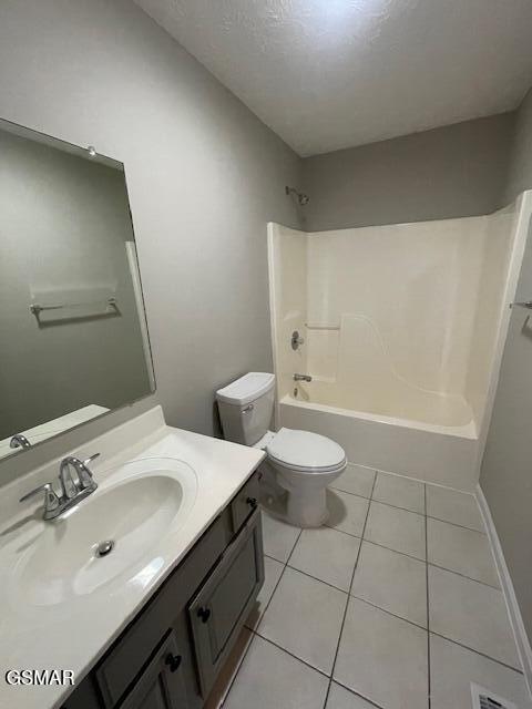 full bath featuring shower / washtub combination, toilet, a textured ceiling, vanity, and tile patterned floors