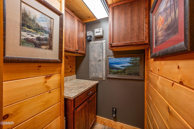 interior space with baseboards, stone counters, and brown cabinets