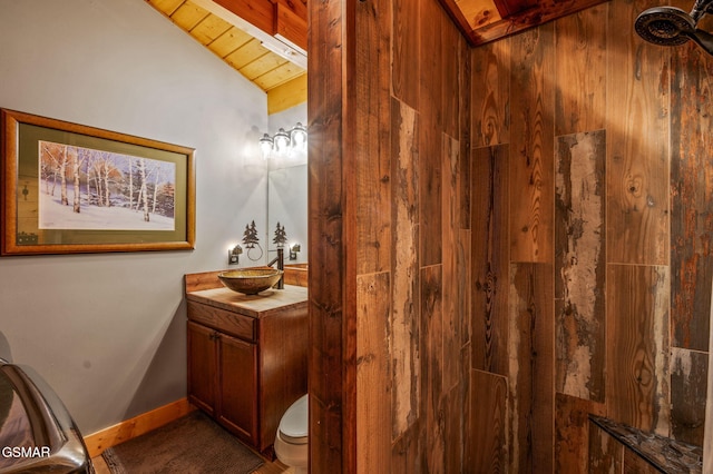 bathroom with toilet, vanity, wooden ceiling, baseboards, and vaulted ceiling with beams