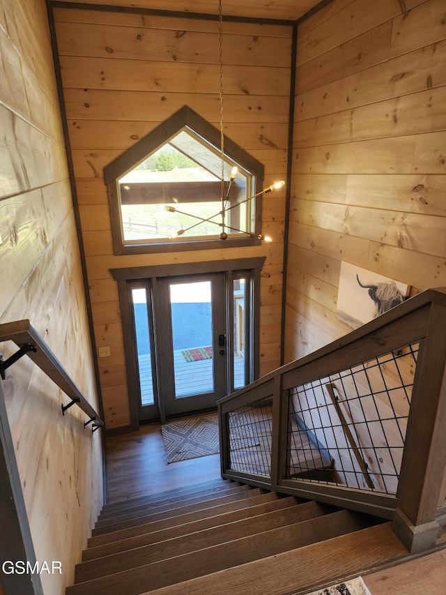 entrance foyer featuring stairway, wood finished floors, and wooden walls