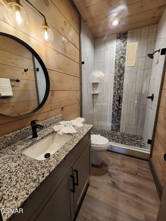 full bath with toilet, wood ceiling, wood finished floors, vanity, and a shower stall