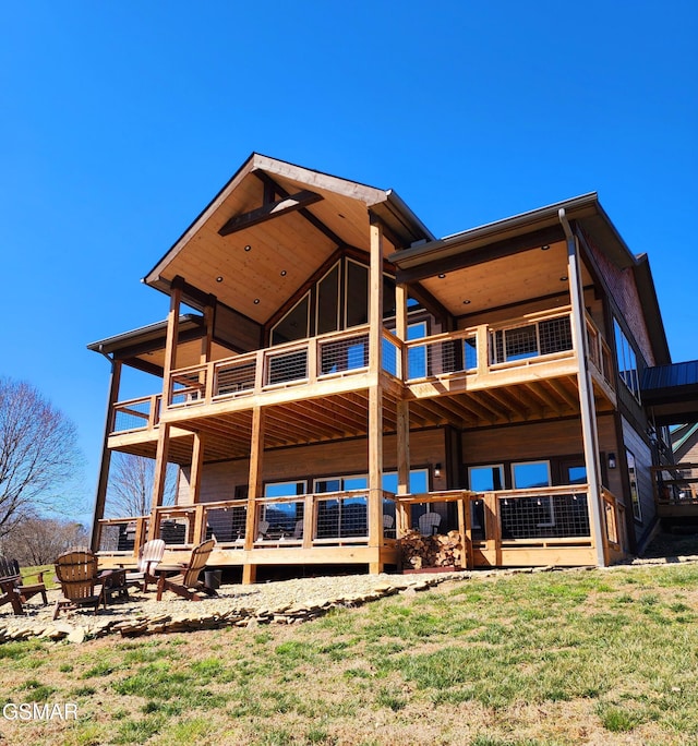 back of property featuring an outdoor fire pit and a yard