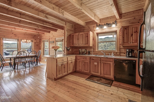 1482 Red Cedar Ln Unit 64, Sevierville, TN 37876 - kitchen with black appliances, a peninsula, a chandelier, wooden walls, and light wood-style floors