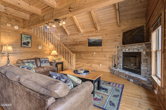 1482 Red Cedar Ln Unit 64, Sevierville, TN 37876 - living room featuring a wood ceiling with exposed beams, wood walls, hardwood / wood-style floors, a stone fireplace, and stairs