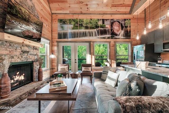 1013 Silver Poplar Ln, Sevierville, TN 37876 - living area featuring high vaulted ceiling, wooden walls, a stone fireplace, and wood ceiling