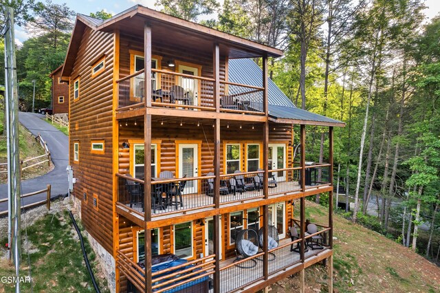1013 Silver Poplar Ln, Sevierville, TN 37876 - rear view of house with log veneer siding, a balcony, a wooden deck, and metal roof
