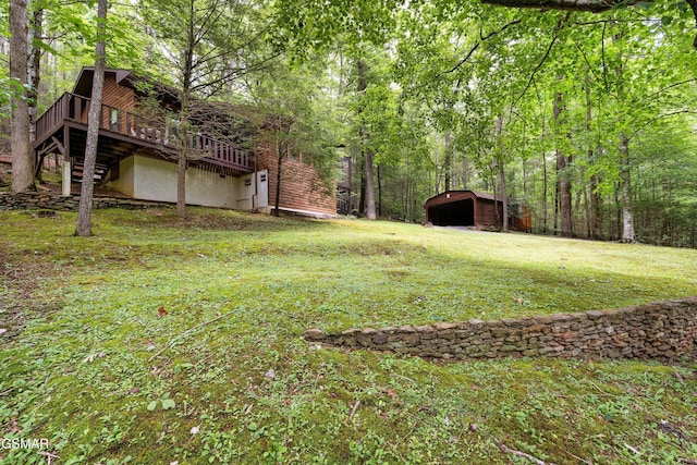 2537 Waldens Creek Rd, Sevierville, TN 37862 - view of green lawn featuring a wooden deck, a carport, an outbuilding, a view of trees, and stairs