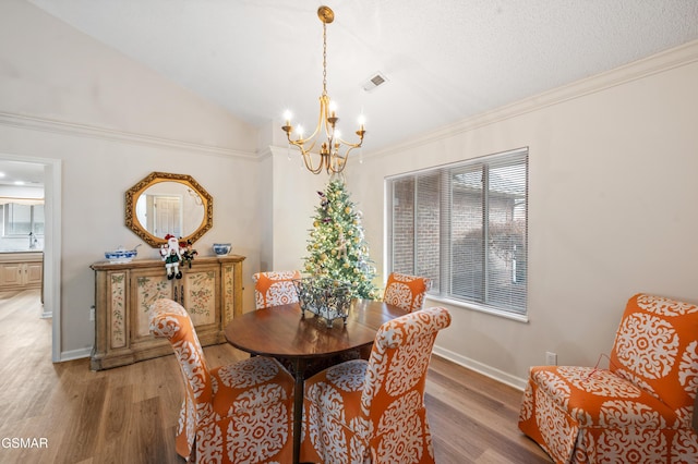 dining room with hardwood / wood-style floors, a notable chandelier, and ornamental molding