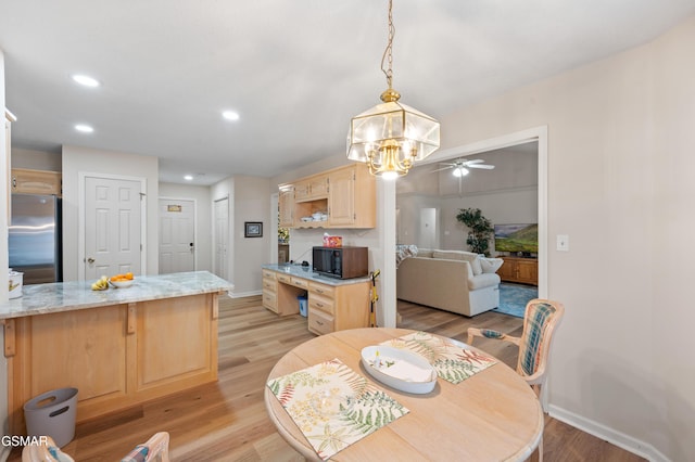 dining room with ceiling fan and light hardwood / wood-style flooring